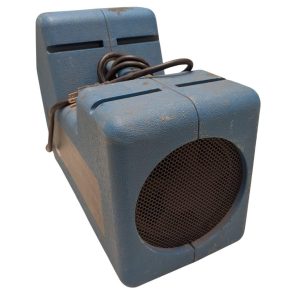 Blue portable speaker with a round front grille and a dusty, worn surface.