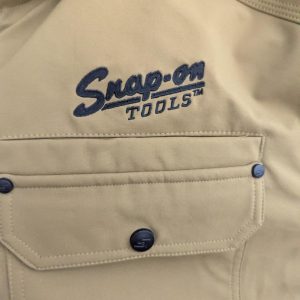 Beige work shirt pocket with Snaps-on Tools logo embroidered above.