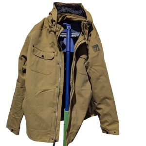 Tan winter/parka jacket with front pockets and an American flag patch on the left sleeve, shown on a blue-green stand.