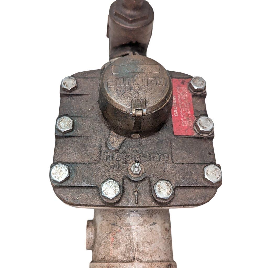 Neptune-3-FH-trident-turbine-awwa-class-II_15 | Chicago HVAC tools and supplies Gas shut-off valve on a rusted metal pipe, featuring a round access cap and bolt-down flange with a red caution label nearby.