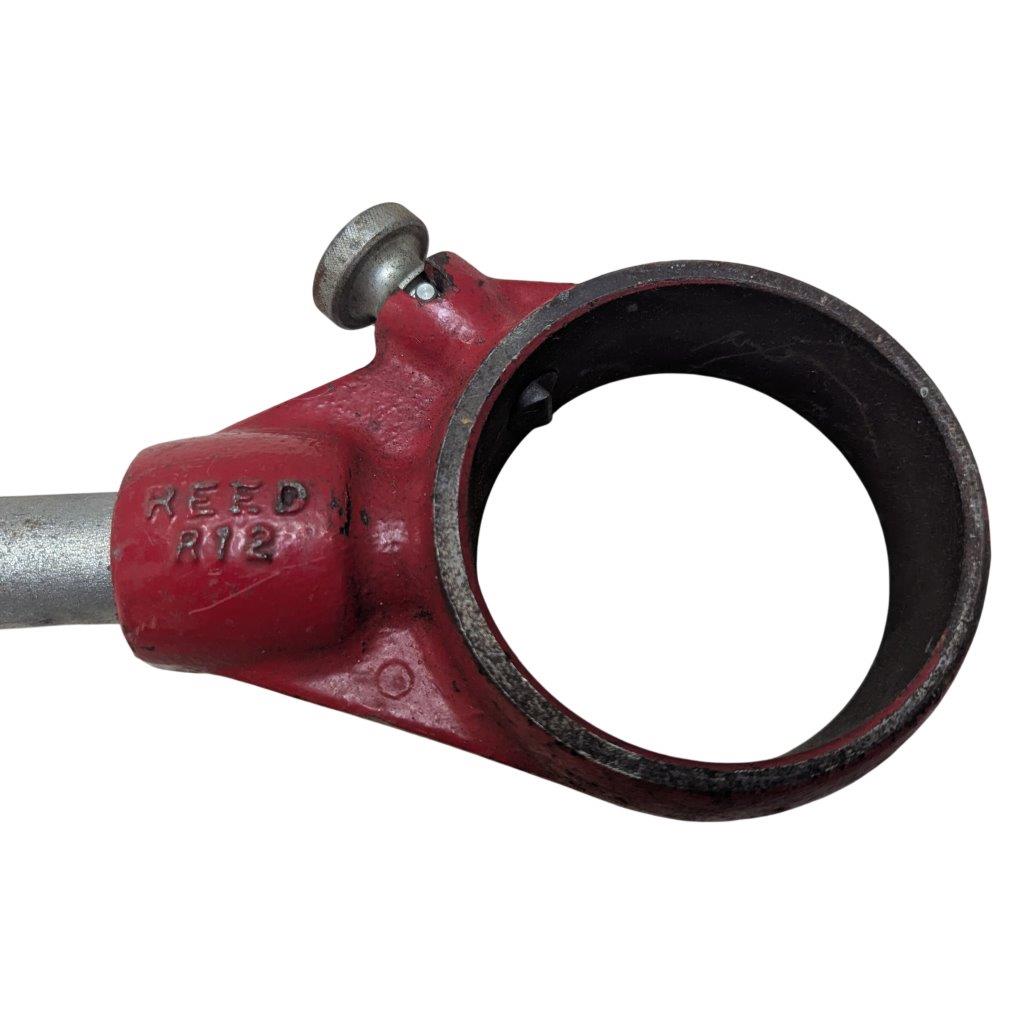 REED-R-12_6 | Chicago HVAC tools and supplies Red pipe clamp with a circular bore and a small screw knob; stamped REED R12.