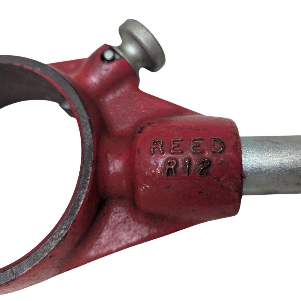 REED-R-12_7 | Chicago HVAC tools and supplies Close-up of a red cast-metal component with a circular opening and the engraving 'REED 812' on the side.