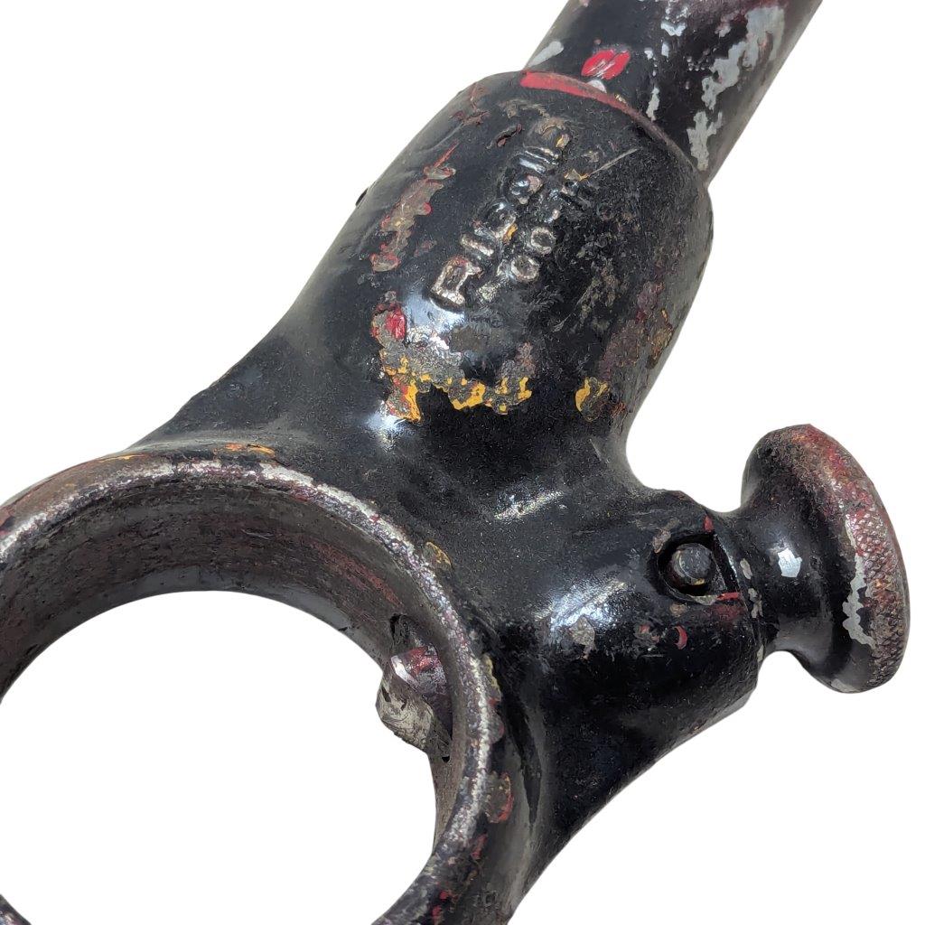 RIDGID-00-R_9 | Chicago HVAC tools and supplies Close-up of a worn, black-painted metal tool with a circular ring and a rounded knob, showing rust and chipped paint.