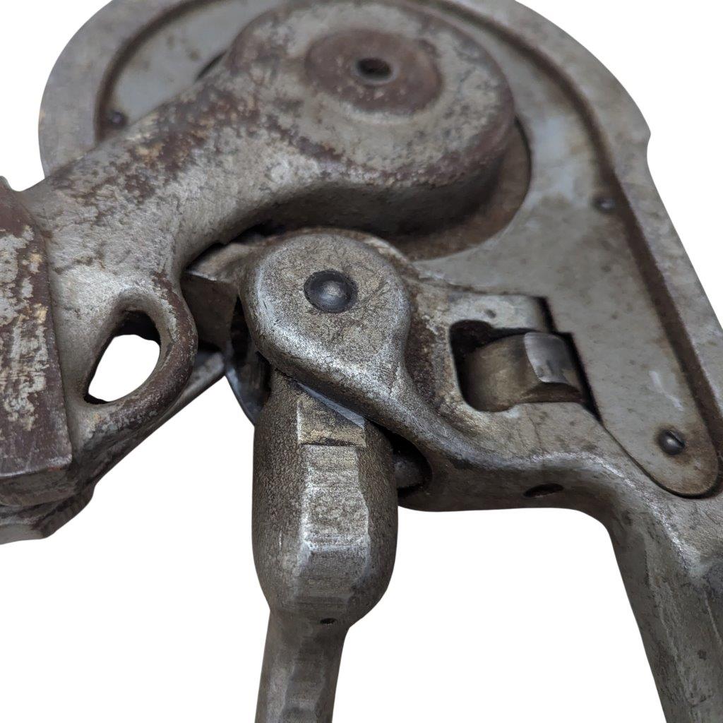 Ridgid-358-Model-Geared-Ratchet-Tube-Bender_6 | Chicago HVAC tools and supplies Close-up of a rusted vintage metal clamp with a lever and pivot.